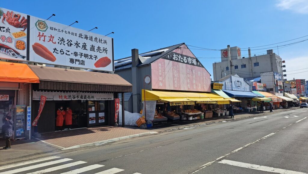 Seafood shops lining both sides of a wide road.