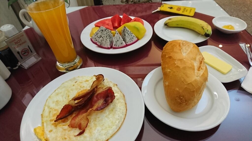 ベトナムホテルの朝食、パンと、目玉焼きと、フルーツ盛り合わせ