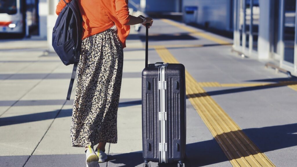 スーツケースが持って街を歩く女性